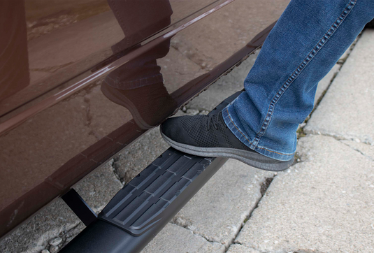 Person stepping on Fishbone Offroad 5 inch oval side step for 2009-2014 Ford F-150 Extended Super Cab.