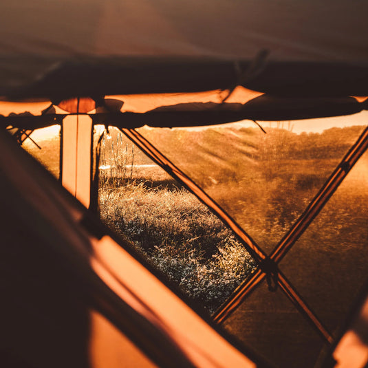 View from inside the Gazelle Tents G6 Deluxe 6-Sided Portable Gazebo during sunset, showcasing the spacious interior and sturdy frame.