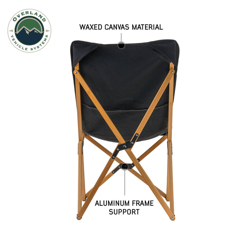 Load image into Gallery viewer, Overland Vehicle Systems Kick It Camp Chair with wood base and storage bag, featuring waxed canvas material and aluminum frame support.
