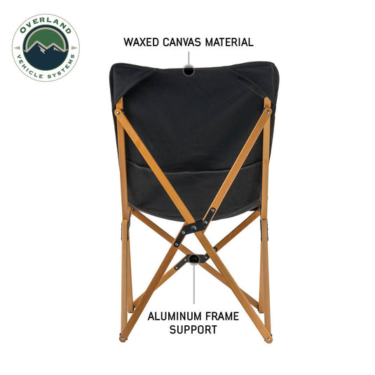 Overland Vehicle Systems Kick It Camp Chair with wood base and storage bag, featuring waxed canvas material and aluminum frame support.
