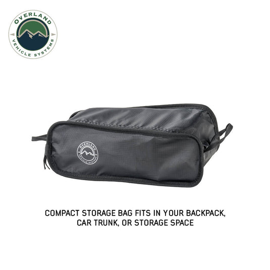 Alt text: "Overland Vehicle Systems Compact Camping Chair storage bag with brand logo, designed to fit in a backpack, car trunk, or storage space."
