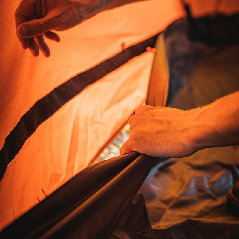 Load image into Gallery viewer, Close-up of a hand setting up a Gazelle T8 Hub Tent, highlighting the tent’s easy-assembly feature for camping enthusiasts.
