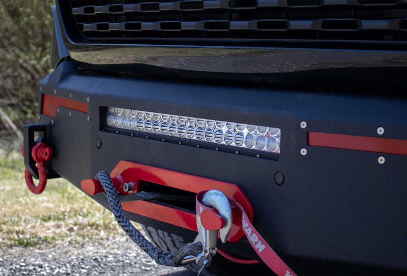Load image into Gallery viewer, Alt text: &quot;Fishbone Offroad 2019-2023 Ram 1500 Pike Winch Plate installed on truck with LED light bar and red tow hook.&quot;
