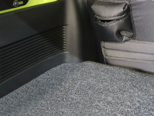 Detailed close-up of the Front Runner Toyota Sequoia 2023 current model Base Deck flooring with textured carpeting and side panel storage pockets.