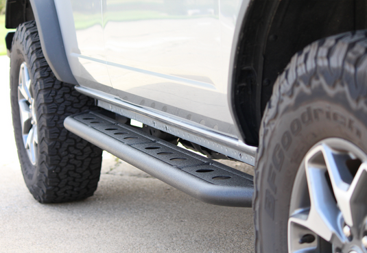 Alt text: "Close-up of Fishbone Offroad Step Sliders installed on a 2022 Ford Bronco, showing rugged design and traction pattern."