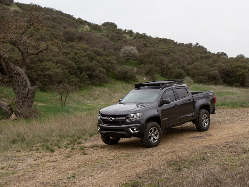 Load image into Gallery viewer, Chevrolet Colorado with Front Runner Slimline II Roof Rack Kit installed, parked in countryside.
