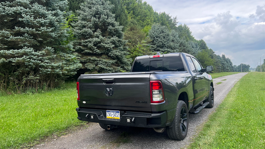 "2019 Ram 1500 with Fishbone Offroad Pike Rear Bumper upgrade parked on side of country road"