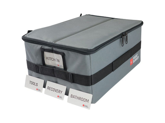 Front Runner Flat Pack storage container with labeled compartments for kitchen, tools, recovery, and bathroom.