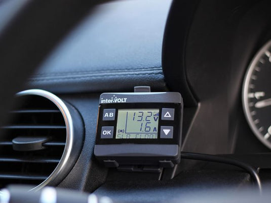 Front Runner Intervolt DCC Pro In-Vehicle DC-DC Battery Charger mounted on car dashboard displaying voltage status.