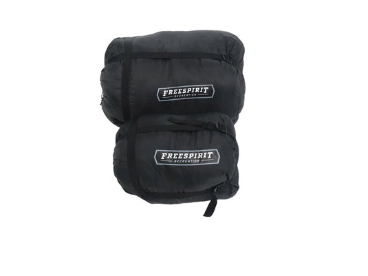 Freespirit Recreation branded black sleeping bag, compressed and strapped for camping.