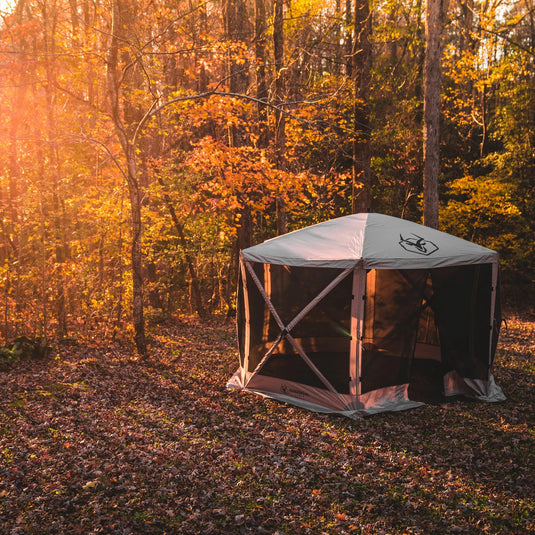 Gazelle Tents G6 6-Sided Portable Gazebo with Wind Panels set up in a forest clearing during autumn.