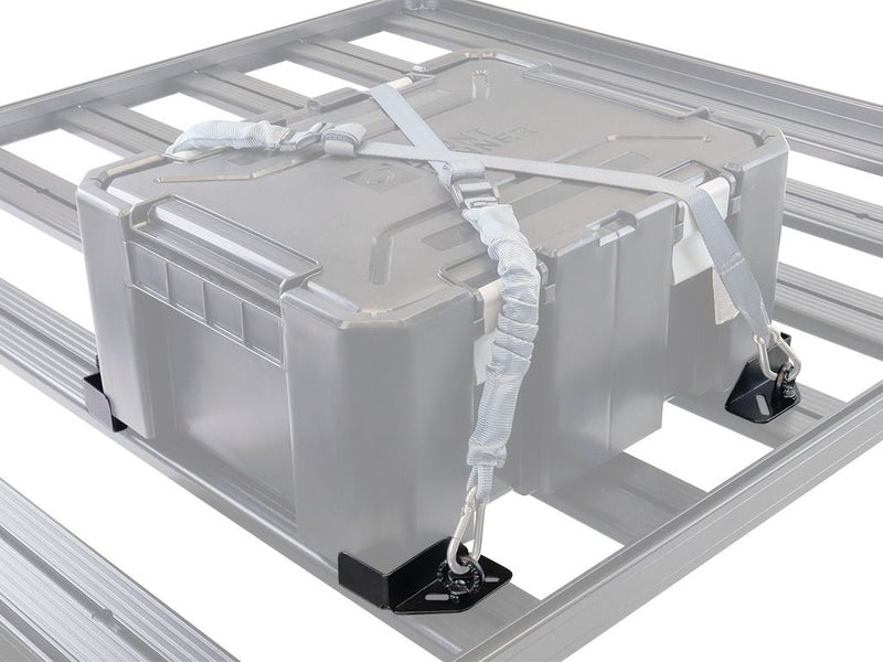 Load image into Gallery viewer, Alt text: &quot;Front Runner Adjustable Rack Cargo Chocks securing a grey storage box on a vehicle roof rack with straps and metal clasps.&quot;
