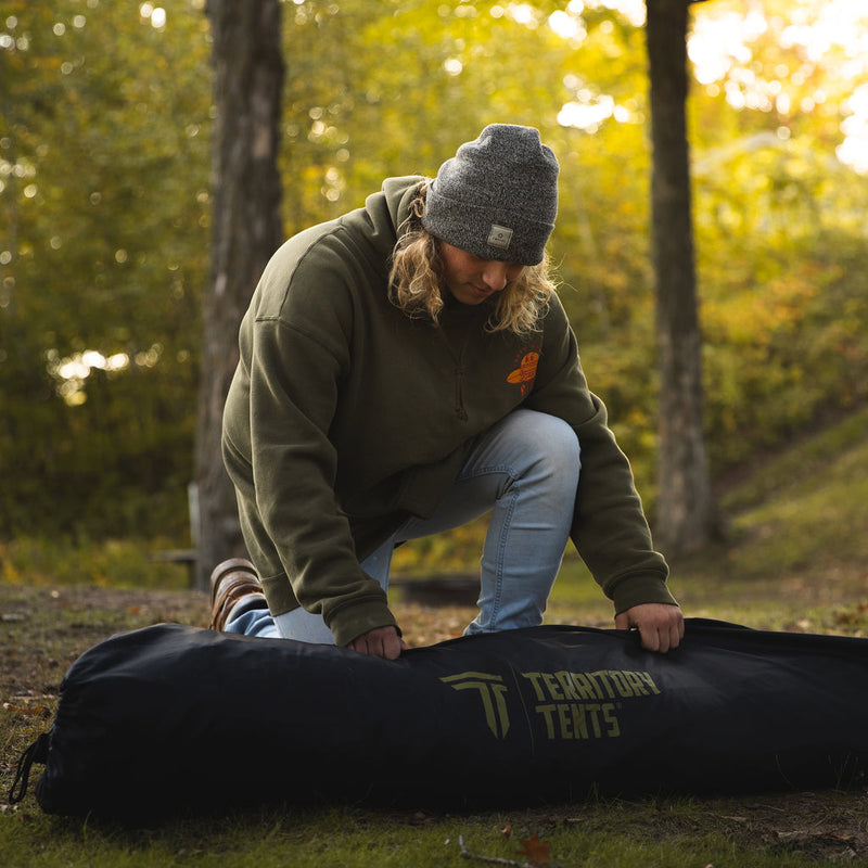 Load image into Gallery viewer, Person unpacking Territory Tents Jet Set 4 Hub Tent from carry bag outdoors
