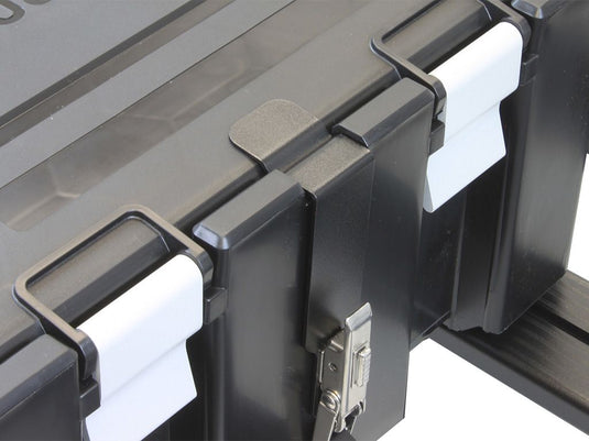 Close-up of Front Runner Wolf Pack Pro Rack Mounting Brackets attached to storage box, showcasing the durable construction and secure latch mechanism.
