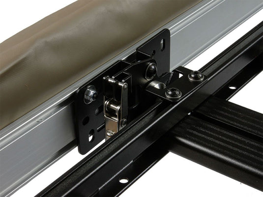 Close-up view of a Front Runner Quick Release Awning Mount Kit installed on a vehicle rack, showcasing the sturdy black metal bracket and bolts for easy attachment and release.