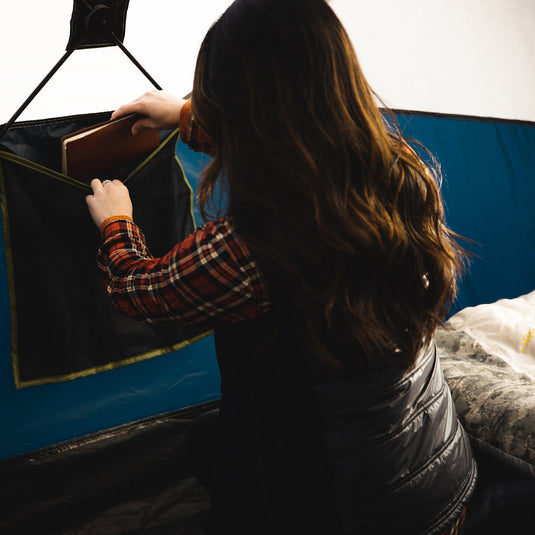 Woman organizing gear inside Territory Tents Jet Set 4 Hub Tent during camping.