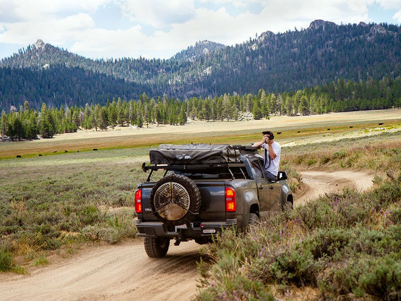 Load image into Gallery viewer, Chevrolet Colorado with Front Runner Slimline II Load Bed Rack Kit in outdoor setting.
