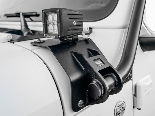 Close-up of a Front Runner roof rack and LED light installed on a white Jeep Wrangler JL 4 Door showing the sturdy build and mounting details.