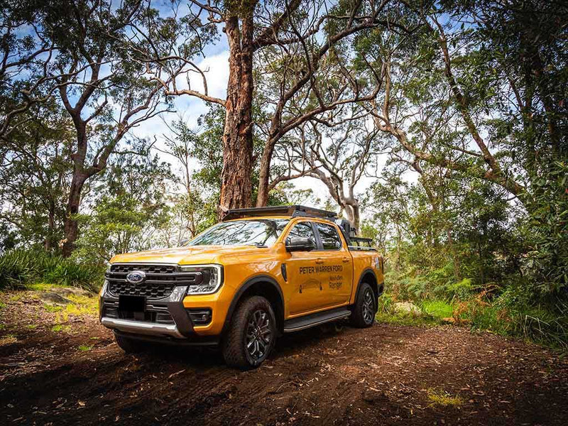 Load image into Gallery viewer, &quot;2022 Ford Ranger T6.2 Double Cab in yellow with Slimline II Roof Rack Kit by Front Runner parked in a natural forest setting&quot;
