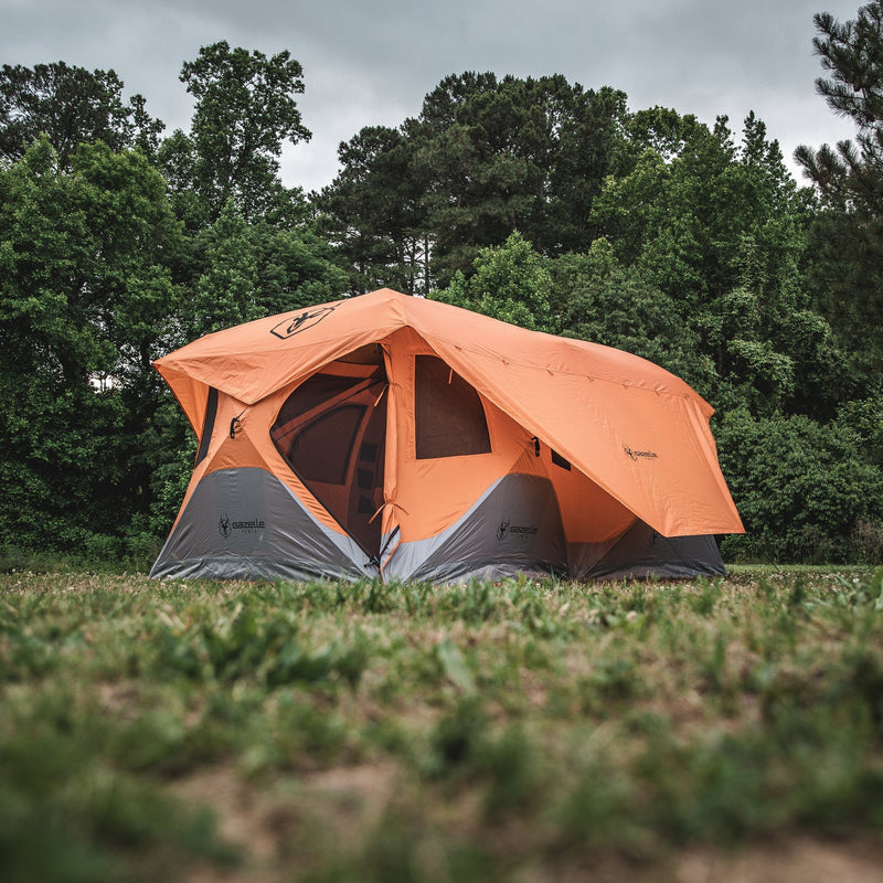 Load image into Gallery viewer, Gazelle Tents T8 Hub Tent set up outdoors on grass with surrounding trees, showcasing the spacious design and easy setup for camping enthusiasts.
