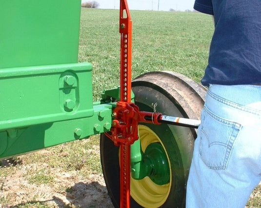 Hi-Lift Jack 42 inch Cast/Steel model being used to lift a green tractor wheel.