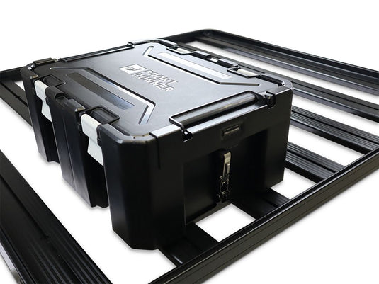 Alt text: "Front Runner Wolf Pack Pro storage box secured with mounting brackets on vehicle rack system, highlighting durable design and locking mechanism."