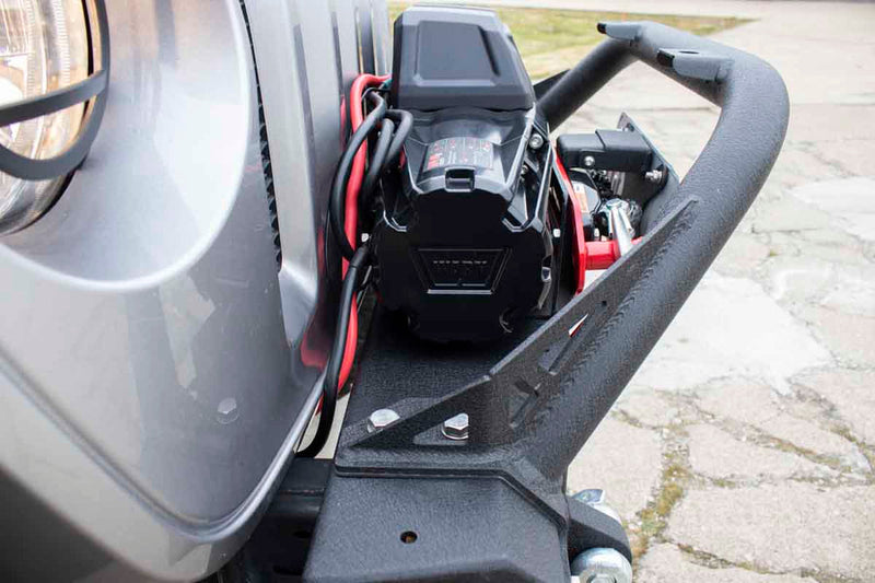 Load image into Gallery viewer, Alt text: Close-up of Fishbone Offroad Barracuda Modular Bumper installed on a Jeep Wrangler, featuring rugged design and integrated winch mount.
