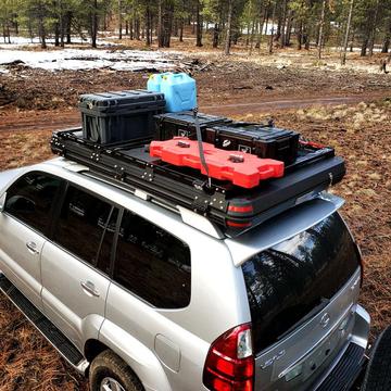 "Freespirit Recreation Odyssey/Evolution Series Cross Bar Kits installed on SUV with roof storage boxes in a forest setting"