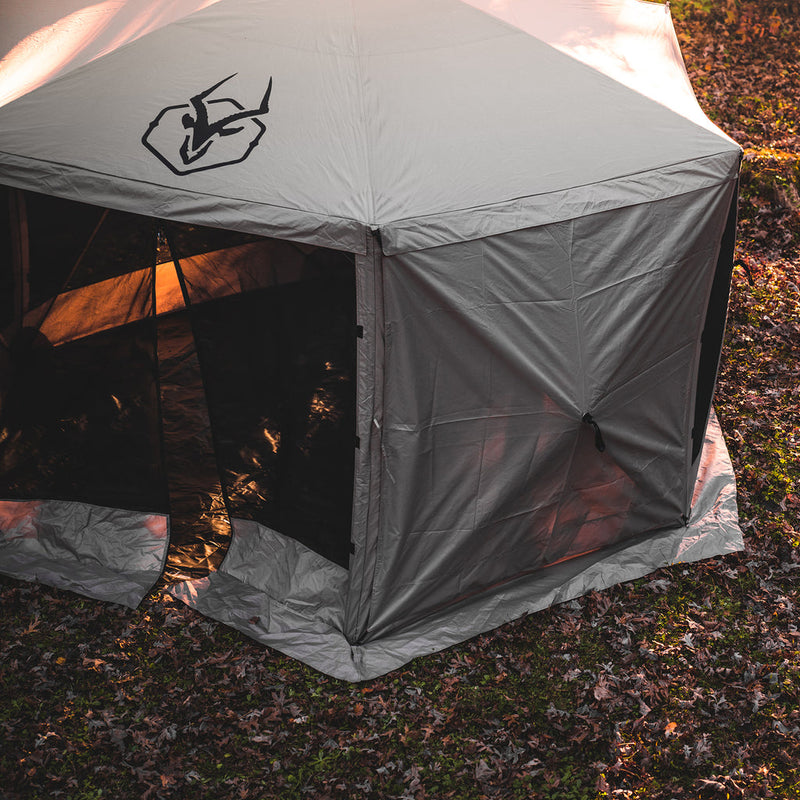 Load image into Gallery viewer, Gazelle Tents Gazebo with Wind Panels attached set up on a leafy ground at dusk.
