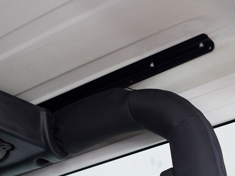 Load image into Gallery viewer, Installation detail of Front Runner Extreme Roof Rack Kit on Jeep Wrangler JK 2 Door, showing the bracket attachment to vehicle roof.
