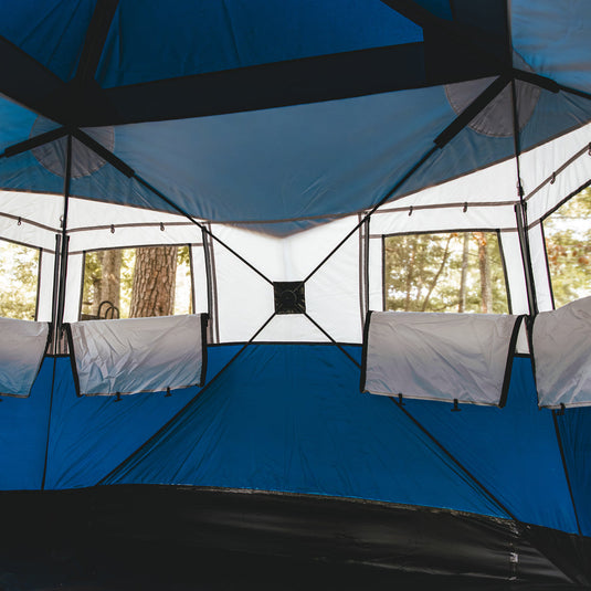 Alt text: "Interior view of Territory Tents Jet Set 3 Hub Tent showing spacious design with see-through mesh windows and built-in storage pockets, set up in a forest."