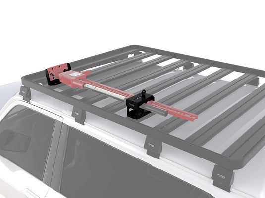 Alt text: inchFront Runner Hi-Lift Jack Bracket mounted on vehicle roof rack, showcasing the top mounting position and secure fit for off-road applications.inch