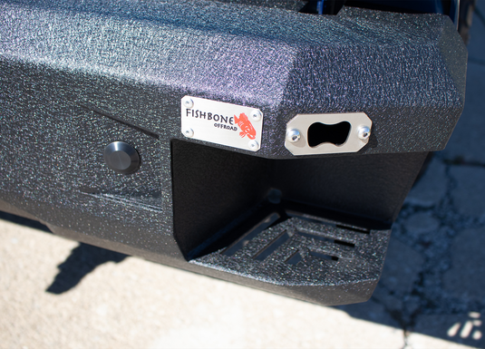 Alt: Close-up of a Fishbone Offroad 2015-Current Ford F-150 Pelican Rear Bumper highlighting the brand logo and textured finish.