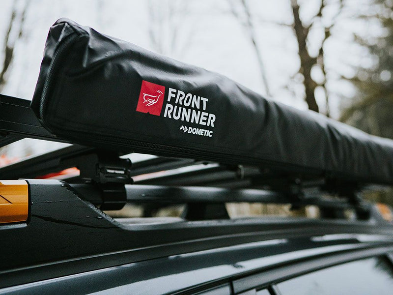 Load image into Gallery viewer, Front Runner Easy-Out Awning 1.4M stored on car roof rack, vehicle camping gear, portable awning for outdoor adventures
