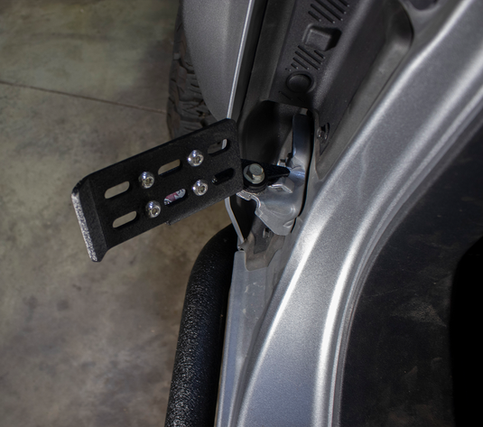 Alt text: "Fishbone Offroad foot peg set installed on a 2022 Ford Bronco, showing the black textured peg attached to the open door."