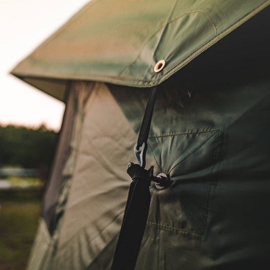 Close-up of Gazelle Tents T4 Hub Tent Overland Edition fabric and tie-down strap with dusk background.