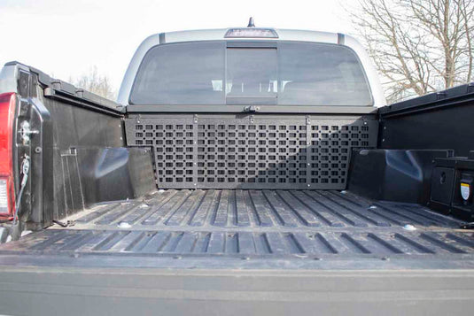 Alt text: "Fishbone Offroad Molle Panel installed on a 2016-2023 Toyota Tacoma truck bed, enhancing organization and storage solutions."