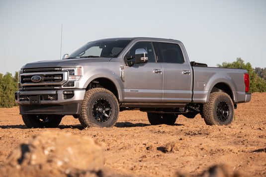 Silver Ford truck equipped with ICON Vehicle Dynamics Rebound HD wheels in Satin Black finish parked on rugged terrain.