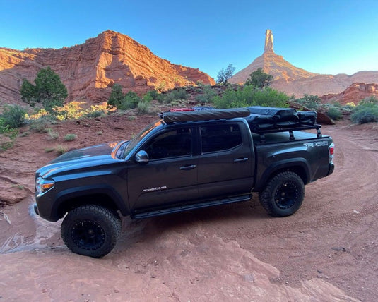 Front Runner Toyota Tacoma with Retrax Slimline II Load Bed Rack Kit parked in desert landscape