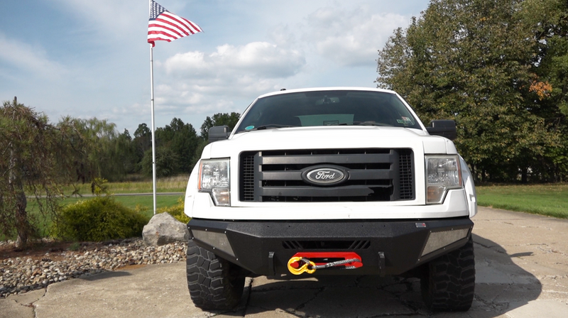 Load image into Gallery viewer, alt=&quot;Fishbone Offroad 2009-2014 F-150 Pelican Front Bumper on white Ford truck with American flag in background&quot;
