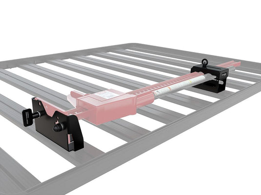 Alt text: inchFront Runner Hi-Lift Jack Bracket mounted on vehicle roof rack, secure top mount jack positioning for off-road vehiclesinch